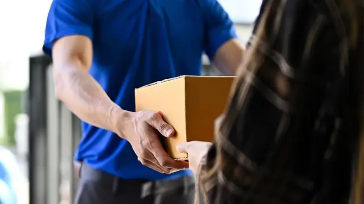Reembolso Correios: funcionário entrega a mercadoria a cliente de e-commerce